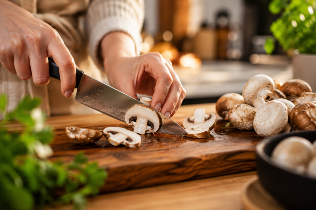Champignons werden für den Süßkartoffel-Linsen-Auflauf geschnitten